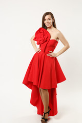 Full length photo of fashion model woman wearing elegant evening dress gown posing isolated on white wall background studio portrait. Brunette long hair girl. Mock up copy space. Red dress face view.