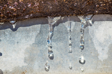 Close-up spring drops on the street in a large macro increase in the sunlight day. Soft and selective focus.