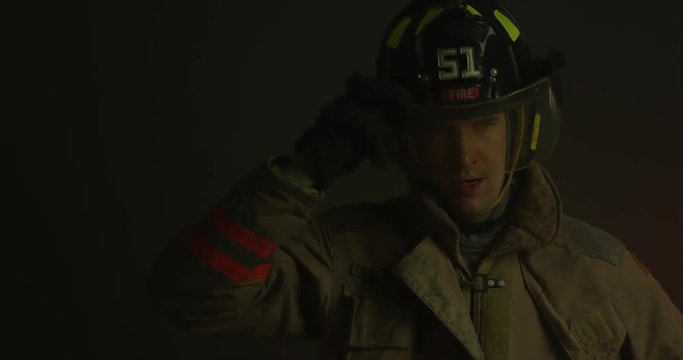 Firefighter puts down helmet visor and inspects situation - medium shot