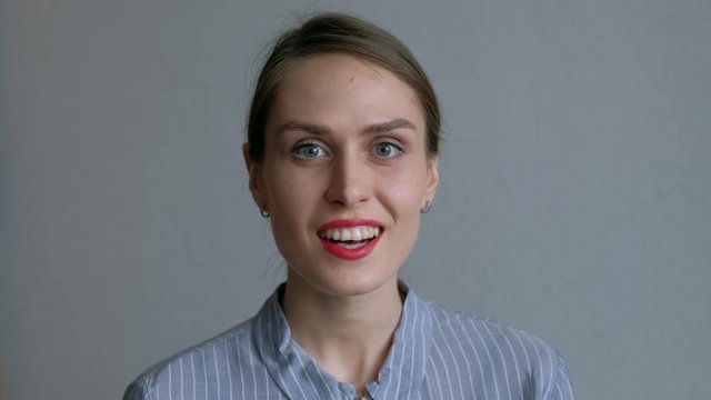 Portrait of young surprised and shocked teen girl on white wall. Surprised excited happy woman with bright red lips. 4k