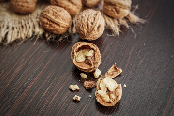 Fototapeta premium Walnuts on a dark wooden table with rustic background