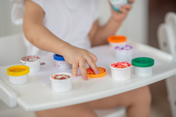 the child draws finger paints close-up of the hand on white paper