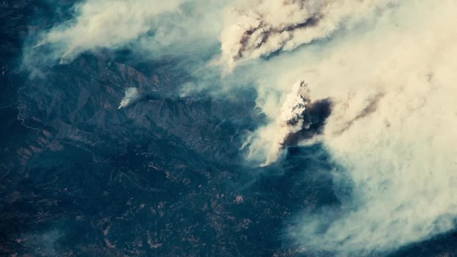 Aerial satellite view of turbulent smoke burning fire on california animation. Contains public domain image by Nasa