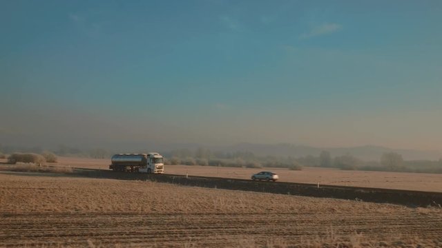 Truck driving past cars on a beautiful morining 