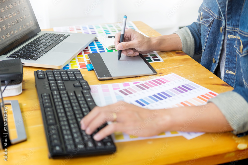 Aufkleber graphic designer team working on web design using color swatches editing artwork using tablet and a 