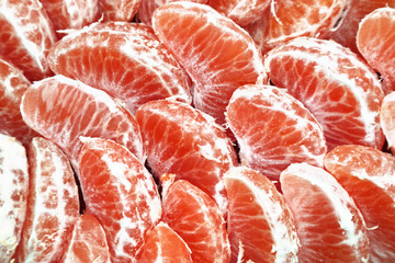 Grapefruit bright juicy peeled slices as background for design.