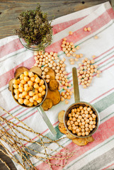 Chickpeas dry and boiled in an iron bowl, thyme. Rustik style background. Top view. Kinfolk and comfort food atmosphere concept.