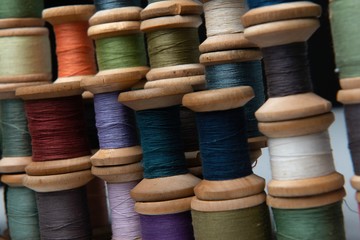 wooden coils with colorful threads of pastel colors