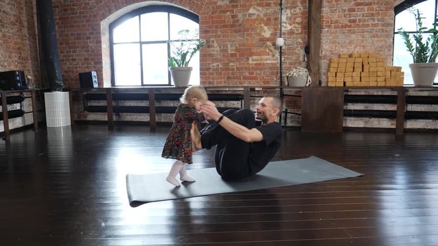 Acro yoga studio father practice a pose with his little child baby daughter