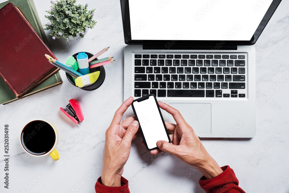 Poster flat lay, top view desk table.man using mobile phone at marble desk table with blank screen laptop c