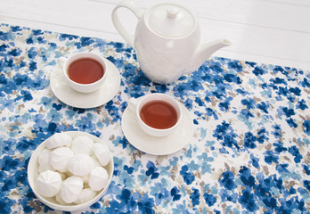 cups of tea with marshmallow on wooden white table