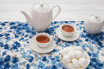 cups of tea with marshmallow on wooden white table