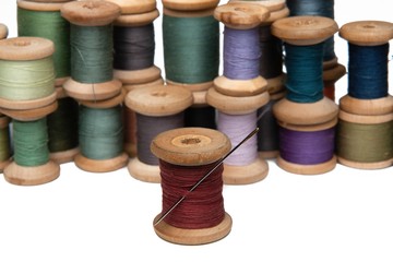 wooden coils with colorful threads of pastel colors