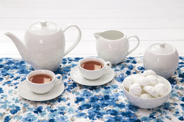cups of tea with marshmallow on wooden white table