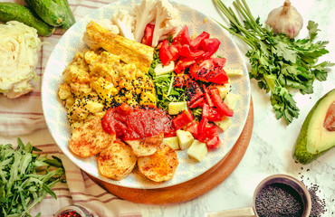 Green fresh salad with tomatoes, pink lentil mashed potatoes, baked potato slices with homemade ketchup.Full meal and Vegetarian spring lunch bowl..Top view.