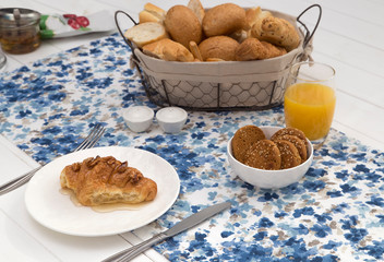 Continental breakfast with fresh croissants, biscuits, bread, jam and orange juice on table