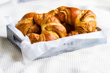 Croissant for breakfast on white woolen surface