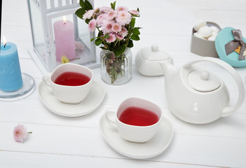 cups of fruit tea on wooden table decorated with flowers
