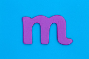 Obraz premium Wooden letter m painted pink on a blue background