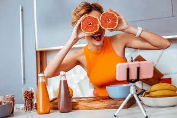 Happy delighted nice woman holding orange halves