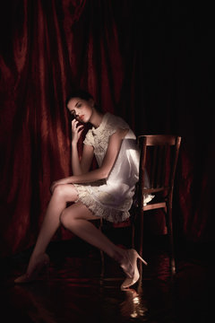 Beautiful woman in white dress on dark burgundy background