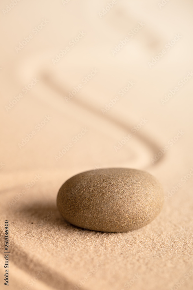 Wall mural spa wellness relaxation stone. Concept for harmony spirituality and mental health. Japanese zen meditation garden with rock in raked sand.