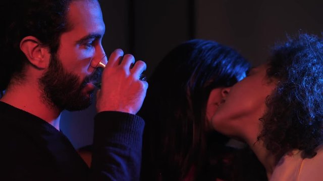 sexy kiss among one man and two women in the dark.Polyamory,poligamy