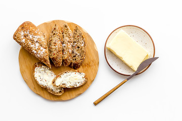 Slice of bread with butter on white background top view