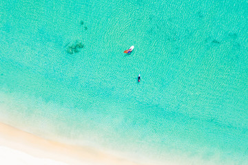 View from above, stunning aerial view of some tourist doing windsurfing and stand up paddle board...