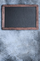 Blackboard with frame on concrete background top view with copy space