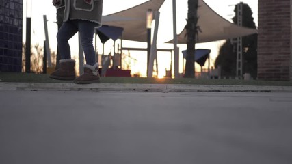 Little girl playing in a playground at sunset