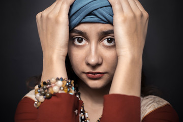 Arab woman in turban on a black background. 