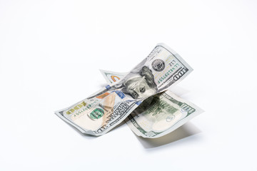 Crumpled dollar banknotes in cross shape form on white background..