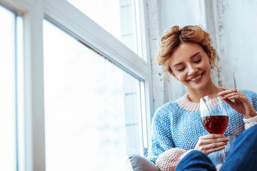 Cheerful positive woman looking at the wine