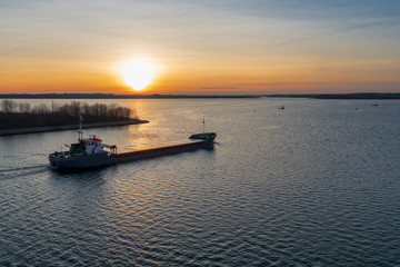 Ein Küstenmotorschiff bei Sonnenaufgang