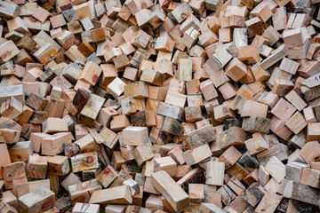 A pile of wooden cubes of pine, waste wood production. Raw materials for the manufacture of sawdust and shavings. 