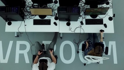 Top view of a modern office with testing games specialists in virtual reality glasses, modern technologies concept. Man and woman in VR glasses playing games.