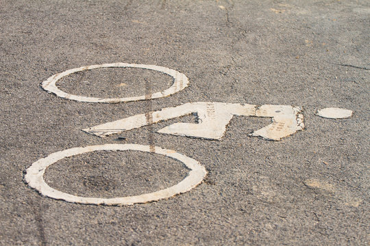 Symbols of bicycle on the street suggests that a bike lane.