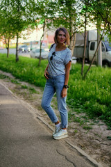 girl in jeans walking on the street, warm spring weather