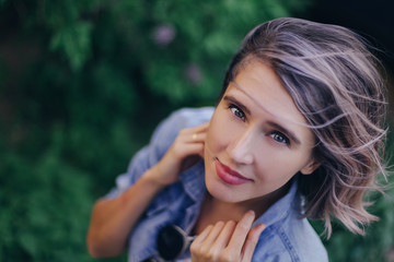 Naklejka premium young girl next to lilac bushes