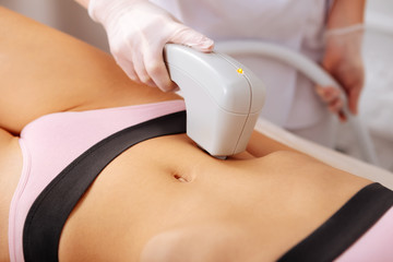 Woman making photo depilation near navel visiting beauty salon