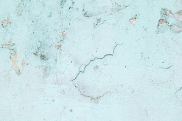 Textured background. Cracked concrete old wall. Light blue paint flakes on old rough concrete surface