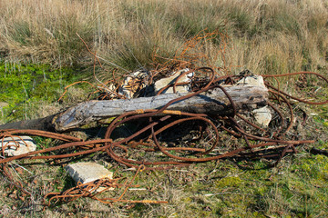 rusty cables, concrete and iron bars dumped in nature