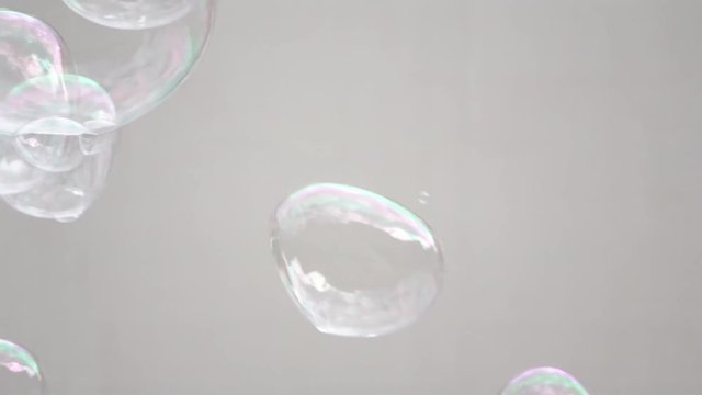 Abstract white background with soap bubbles, pubblic entertainment. Slow motion