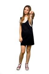 Fototapeta premium Full body Young pretty woman showing thumb down sign with negative expression on isolated background