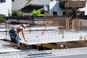 Worker guides the descending concrete slab at the construction site.