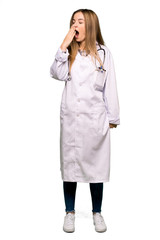 Full body Young doctor woman yawning and covering wide open mouth with hand on isolated background