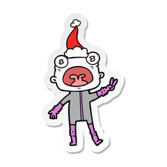 sticker cartoon of a weird alien waving wearing santa hat
