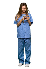 Full body Young nurse sending a message with the mobile on isolated background
