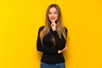 Young pretty woman over yellow background smiling and looking to the front with confident face